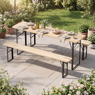 Outdoor dining setup with a wooden table and benches on a patio, surrounded by greenery and flowers.