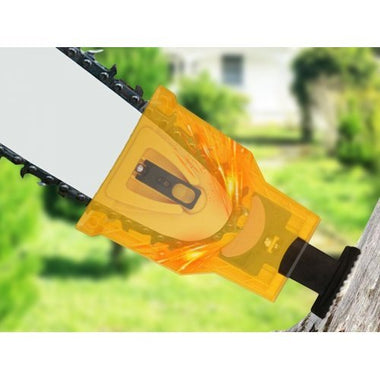 Close-up of a chainsaw with a transparent orange guard on a blurred green background
